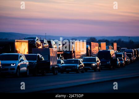 Przemysl, Polen. 12. April 2022. Fahrzeuge stehen auf polnischer Seite vor dem Grenzübergang Medyka an, um in die Ukraine einzureisen. Quelle: Christoph Soeder/dpa/Alamy Live News Stockfoto