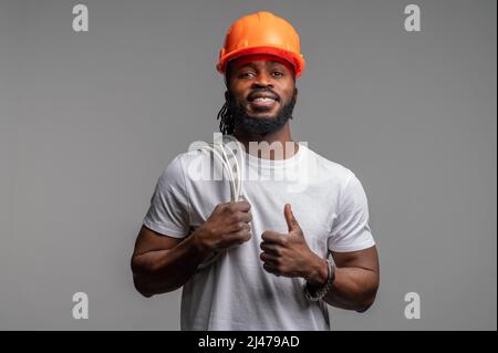 Zufrieden Ingenieur mit dem Kabel über seiner Schulter und Blick nach vorne Stockfoto