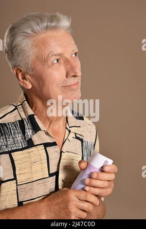 Älterer Mann, der zu Hause Euro hält Stockfoto