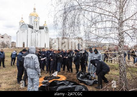 Bucha, Ukraine. 12. April 2022. (ANMERKUNG DER REDAKTION: Bild zeigt den Tod) .Forensische Polizisten exhumieren Leichen in Bucha, am Stadtrand von Kiew. Bucha City in der Ukraine wurde unter intensiven Kämpfen und Beschuss-Angriffen aus Russland verwüstet. Der Völkermord-Angriff der russischen Streitkräfte tötete Hunderte von Zivilisten in der Stadt. Die russischen Angriffe führen auch dazu, dass einige Einheimische obdachlos sind und auf der Straße leben. (Bild: © Mykhaylo Palinchak/SOPA Images via ZUMA Press Wire) Stockfoto