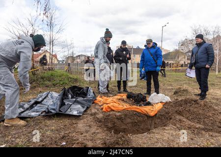 Bucha, Ukraine. 12. April 2022. (ANMERKUNG DER REDAKTION: Bild zeigt den Tod) .Forensische Polizisten exhumieren Leichen in Bucha, am Stadtrand von Kiew. Bucha City in der Ukraine wurde unter intensiven Kämpfen und Beschuss-Angriffen aus Russland verwüstet. Der Völkermord-Angriff der russischen Streitkräfte tötete Hunderte von Zivilisten in der Stadt. Die russischen Angriffe führen auch dazu, dass einige Einheimische obdachlos sind und auf der Straße leben. (Bild: © Mykhaylo Palinchak/SOPA Images via ZUMA Press Wire) Stockfoto