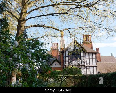 Watford, Hertfordshire, England, April 07 2022: Baum, Blumenbeete, Hecke und Bank auf dem Gelände von Bhaktivedanta Manor, einem ISKCON-Standort. Stockfoto