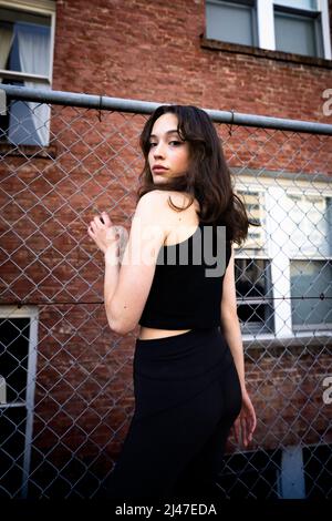 Teenage Dancer in Downtown Berkeley posiert mit Chainlink Zaun Stockfoto