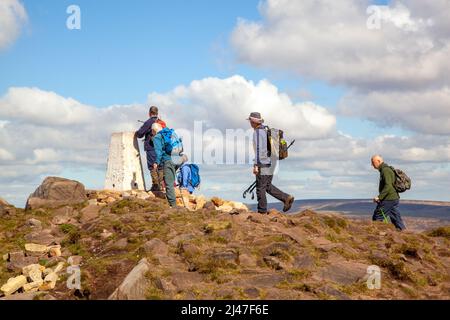 Männer am trig Point Hill wandern im Peak District National Park auf den Roaches Range von Felsen in den Staffordshire Moorlands Leek Staffordshire Stockfoto