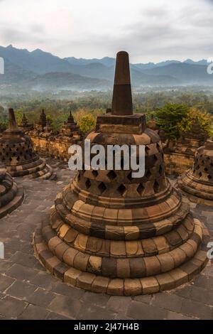 Borobudur, Java, Indonesien. Stupas auf der oberen Terrasse des Tempels Warten auf den Sonnenaufgang. Stockfoto