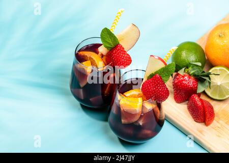 Zubereitung des traditionellen spanischen Sommergetränks Sangria mit frischen Früchten, Rotwein und Eiswürfeln. Stockfoto