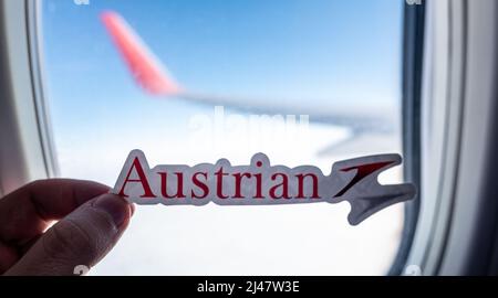 6. Dezember 2021, Wien, Österreich. Das Emblem der Austrian Airlines vor dem Hintergrund eines Flugzeugfensters. Stockfoto