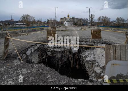 Makariv, Kiew, Ukraine. 12. April 2022. Ein Loch zur Reparatur auf der Brücke gesehen. Das Dorf Makariv, westlich von Kiew, zeigt offensichtliche Anzeichen von Schäden während der russischen Besatzung, dauerte bis Ende März 2022. Die Bewohner versuchen, mit grundlegenden Reparaturen und Kontrollen mit der Situation fertig zu werden. (Bild: © Valeria Ferraro/ZUMA Press Wire) Stockfoto