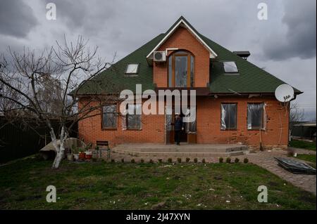 Makariv, Kiew, Ukraine. 12. April 2022. Ein Bewohner sah Schadenersatz an seinem Haus. Das Dorf Makariv, westlich von Kiew, zeigt offensichtliche Anzeichen von Schäden während der russischen Besatzung, dauerte bis Ende März 2022. Die Bewohner versuchen, mit grundlegenden Reparaturen und Kontrollen mit der Situation fertig zu werden. (Bild: © Valeria Ferraro/ZUMA Press Wire) Stockfoto