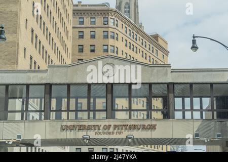 Pittsburgh, Pennsylvania, USA-8. April 2022: Studenten können einen erhöhten Fußgängerüberweg über die Forbes Avenue auf dem Campus der University of Pittsburgh nutzen. Stockfoto