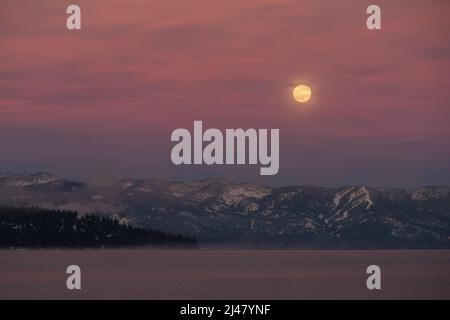 Vollmond über dem Lake Tahoe im Winter Stockfoto