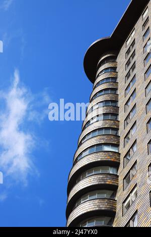 Blick von außen auf ein wunderschönes, modernes Gebäude mit Apartments, die wie ein Wolkenkratzer gebaut wurden. Stockfoto