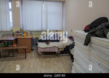 Chisinau, Moldawien. 8. April 2022. Ein Roma-Mann ruht mit seinem Sohn in einem der Zimmer des Zigeunergeflüchtlingszentrums. Das Roma-Volk "roma", auch bekannt als "Zigeuner", gehört zu den 4 Millionen Menschen, die durch Gewalt aus dem bewaffneten Konflikt in der Ukraine vertrieben wurden und in Flüchtlingshilfezentren in verschiedenen Teilen der Republik Moldau untergebracht sind. Sie sind in der Regel organisiert und von anderen Gruppen getrennt.Es gibt keine genauen Daten, aber nach Angaben von Organisationen wie dem FundaciÃ³n Secretariado Gitano leben etwa 400.000 Roma in der Ukraine. (Bild: © Israel Fuguemann/SOPA Images vi Stockfoto