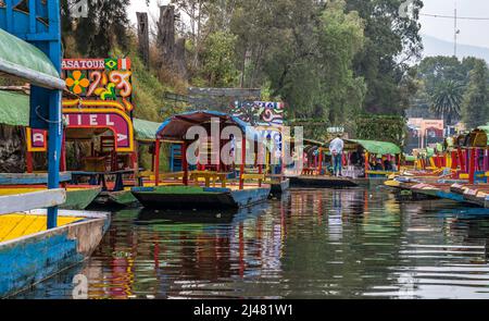 MEXIKO-STADT - 19. Dezember 2021. Bunte Boote, die auf einem Kanal in den schwimmenden Gärten von Mexiko geparkt sind. Stockfoto