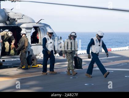 220404-N-TT639-1168 PAZIFISCHER OZEAN (4. April 2022) – Master Chief Petty Officer of the Navy (MCPON) Russell Smith, Mitte, kommt an Bord des amphibischen Angriffsschiffs USS Tripoli (LHA 7), 4. April. Tripolis führt derzeit Routineoperationen in der US 3.-Flotte durch. (USA Navy Foto von Mass Communication Specialist 3. Class Christopher Sypert) Stockfoto