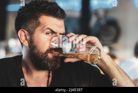 Bärtiger Mann mit einem Glas Bier. Genießen Sie es im Pub. Bierzeit. Bärtiger Mann mit einem Glas Bier. Stockfoto