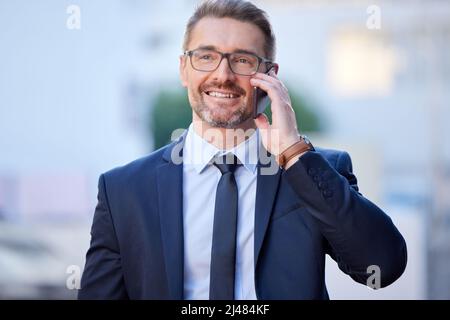 Ich treffe Sie in zehn Jahren im Büro. Eine kurze Aufnahme eines gutaussehenden, reifen Geschäftsmannes, der einen Anruf tätigen kann, während er draußen in der Stadt steht. Stockfoto