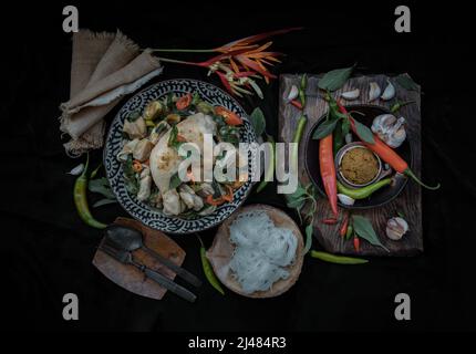 Grünes Kerrys mit Hühnchen und grün-weißen Sorten thailändischer Auberginen (Kaeng Khiao wan) in einer Keramikschale serviert mit thailändischen Reisnudeln (fermentierter Reis f Stockfoto