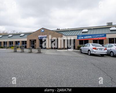 Lynnwood, WA USA - ca. April 2022: Ansicht eines "Now Hiring"-Schildes vor dem Mill Creek United States Postal Service Gebäude Stockfoto