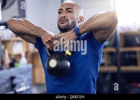 Ein starker Geist macht einen starken Körper aus. Aufnahme eines jungen Mannes, der mit einer Kesselglocke im Fitnessstudio trainieren soll. Stockfoto