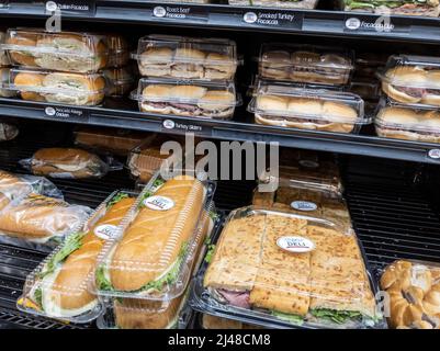 Woodinville, WA USA - ca. April 2022: Schräge Ansicht von Deli-Subs und Sandwiches zum Verkauf im Feinkostgeschäft eines Haggen-Lebensmittelladens. Stockfoto