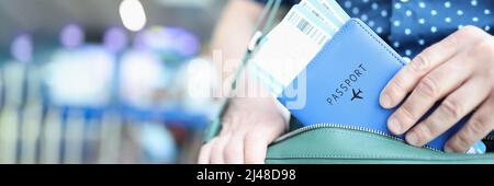 Mann, der den Pass mit Flugtickets in die Laptoptasche in der Nähe legte Stockfoto