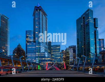 Nachtaufnahme moderner Gebäude in der Innenstadt von Vancouver. Langzeitbelichtung der Innenstadt von Vancouver. Bunte Stadtnacht mit Wolkenkratzern. Straßenfoto, wählen Sie aus Stockfoto