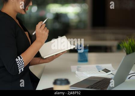 Schöne asiatische Geschäftsfrau, die sich das pädagogische Webinar auf einem Laptop ansieht. Finanzierungskonzept. Stockfoto
