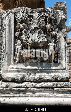 Ein aus Stein gemeißeltes Relief mit menschlichen Figuren, das sich in den Hadrianbädern von Aphrodisias in der Türkei befindet. Die Bäder waren es Stockfoto