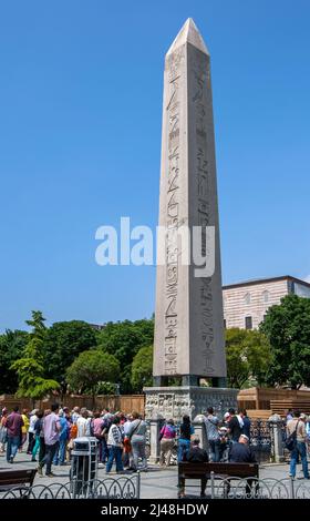 Touristen versammeln sich um den Fuß des rosafarbenen Granitobelisken von Theodosius am Hippodrom im Sultanahmet-Viertel von Istanbul in der Türkei. Stockfoto