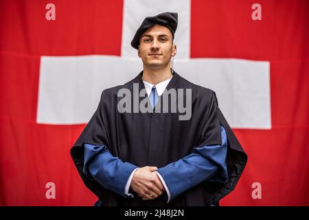 Rom, Italien. 09. April 2022. Der 21-jährige Schweizer Wachmann Gian Andrea Bossi steht in den Kasernen der Schweizer Garde vor einer Schweizer Flagge. Mit ihren farbenfrohen Renaissance-Uniformen sind die Schweizer Garde ein muss für viele Touristen in Rom, aber die Kasernen des päpstlichen Leibwächters sind nicht gerade auffällig. Die Soldaten sollten besser leben. (To dpa 'Streit um Kasernen der Schweizer Garde in Rom') Quelle: Oliver Weiken/dpa/Alamy Live News Stockfoto