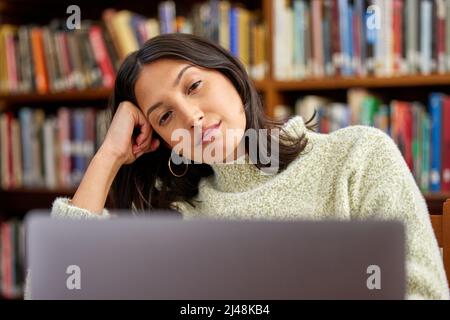 Lassen Sie sich nicht von der Angst vor dem Scheitern abschrecken. Aufnahme einer hispanischen Frau, die einen Laptop benutzt und in einer Bibliothek gestresst ist. Stockfoto