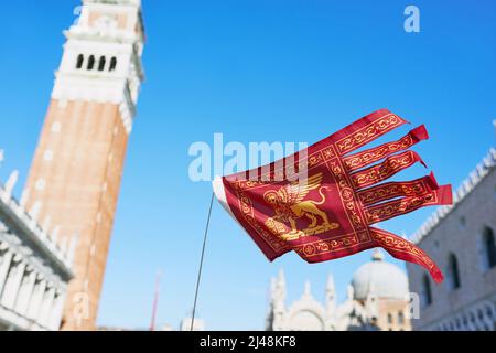 VENEDIG, ITALIEN - 17. OKTOBER 2021: Flagge Venedigs auf dem Markusplatz im Hintergrund. Stockfoto