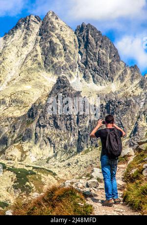 Wanderer mit Blick auf Hügel und schießende Gipfel in der Hohen Tatra, Slowakei. Wandern im Sommer Stockfoto