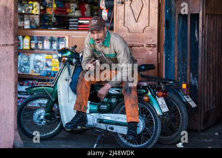 Marrakesch, Marokko - 28. März 2022: Eine typische Straße im alten Medina-Viertel von Marrakesch. Auf dem Foto sind Einheimische zu sehen, die verschiedene Aktivitäten durchführen. Stockfoto