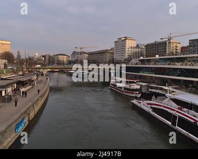 Schöner Blick über den Donaukanal in der Innenstadt von Wien, Österreich mit Anlegebooten am Ufer umgeben von Gebäuden. Stockfoto