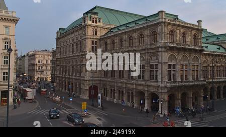 Rückansicht des imposanten historischen Gebäudes der Wiener Staatsoper in Österreich am Abend mit Steinfassade und Stadtstraße davor. Stockfoto