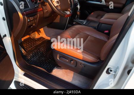 Auto im Fahrerplatz. Brauner Innenraum des modernen Prestige-Autos. Vordersitze mit Lenkrad-Armaturenbrett. Nach dem Waschen und Detaillieren. Stockfoto