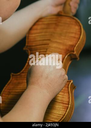 geigenbauer lackiert eine klassische Violine Stockfoto