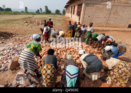 Umuganda monatlicher Gemeindedienst. Hier arbeiten sie am Bau von Klassenräumen für 12 Jahre Grundbildung an der Mwurire Groupe Scolare Schule, Mbazi Sektor, Huye District. Foto von Mike Goldwater Stockfoto