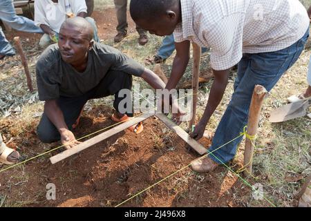 Umuganda monatlicher Gemeindedienst. Hier arbeiten sie am Bau von Klassenräumen für 12 Jahre Grundbildung an der Mwurire Groupe Scolare Schule, Mbazi Sektor, Huye District. Foto von Mike Goldwater Stockfoto