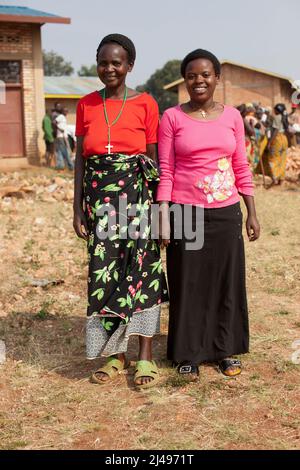 Paskazi Mukasangwa, 60, Projektbegünstigter, mit Tochter Chantel, 24. Die Mutter hat die Gelder, die sie aus dem Projekt gelernt hat, verwendet, um Chantel in die weiterführende Schule zu schicken. Umuganda monatlicher Gemeindedienst für den Bau von Klassenzimmern für 12 Jahre Grundbildung. Die Schule Mwurire Groupe Scolare, Mbazi Sektor, Huye District. Foto von Mike Goldwater Stockfoto