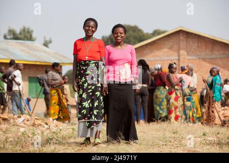 Paskazi Mukasangwa, 60, Projektbegünstigter, mit Tochter Chantel, 24. Die Mutter hat die Gelder, die sie aus dem Projekt gelernt hat, verwendet, um Chantel in die weiterführende Schule zu schicken. Umuganda monatlicher Gemeindedienst für den Bau von Klassenzimmern für 12 Jahre Grundbildung. Die Schule Mwurire Groupe Scolare, Mbazi Sektor, Huye District. Foto von Mike Goldwater Stockfoto