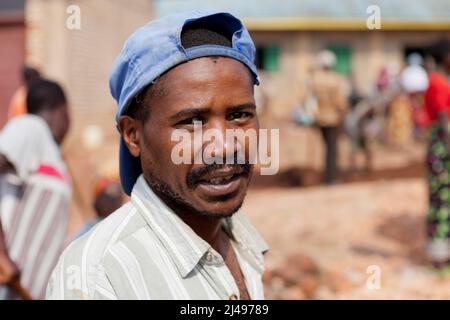 Corneille Karekezi, 39, eine Benefizid des Programms, das am monatlichen Gemeindedienst von Umuganda arbeitet. Hier arbeiten sie am Bau von Klassenräumen für 12 Jahre Grundbildung an der Mwurire Groupe Scolare Schule, Mbazi Sektor, Huye District. Foto von Mike Goldwater Stockfoto