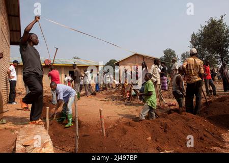 Umuganda monatlicher Gemeindedienst. Hier arbeiten sie an der Errichtung von Klassenräumen für 12 Jahre Grundbildung bei der Mwurire Groupe Scolare sch Stockfoto