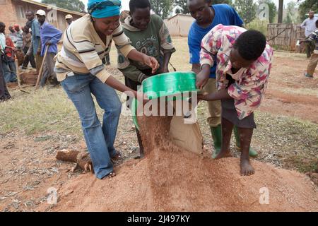 Umuganda monatlicher Gemeindedienst für den Bau von Klassenzimmern für 12 Jahre Grundbildung. Die Schule Mwurire Groupe Scolare, Mbazi Sektor, Huye District. Stockfoto