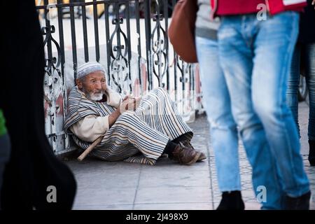 Marrakesch, Marokko - April 22,2022: Bettler und Obdachlose auf den Straßen des alten Medina-Viertels von Marrakesch. Stockfoto