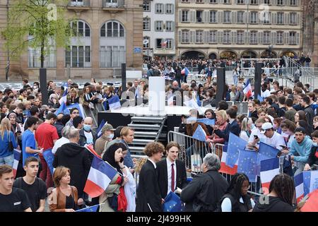 Die Öffentlichkeit und die Unterstützer warten auf die Ankunft des Kandidaten Emmanuel Macron bei seinem Treffen in Straßburg. Die Ordnungskräfte sichern die Demonstration und blockieren die Demonstranten. Eine starke Präsenz junger Menschen nimmt an diesem Moment Teil. 13. April 2022 in Straßburg, im Nordosten Frankreichs. Foto von Nicolas Roses/ABACAPRESS.COM Stockfoto
