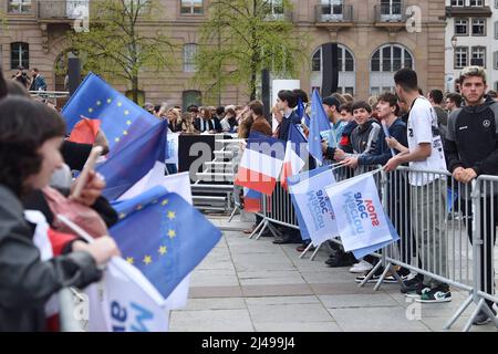 Die Öffentlichkeit und die Unterstützer warten auf die Ankunft des Kandidaten Emmanuel Macron bei seinem Treffen in Straßburg. Die Ordnungskräfte sichern die Demonstration und blockieren die Demonstranten. Eine starke Präsenz junger Menschen nimmt an diesem Moment Teil. 13. April 2022 in Straßburg, im Nordosten Frankreichs. Foto von Nicolas Roses/ABACAPRESS.COM Stockfoto