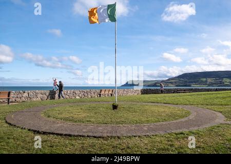 Grünes Weiß und Orange der irischen Tricolor-Flagge, die über den Hafen von Carnlough in der Grafschaft Antrim fliegt. Stockfoto